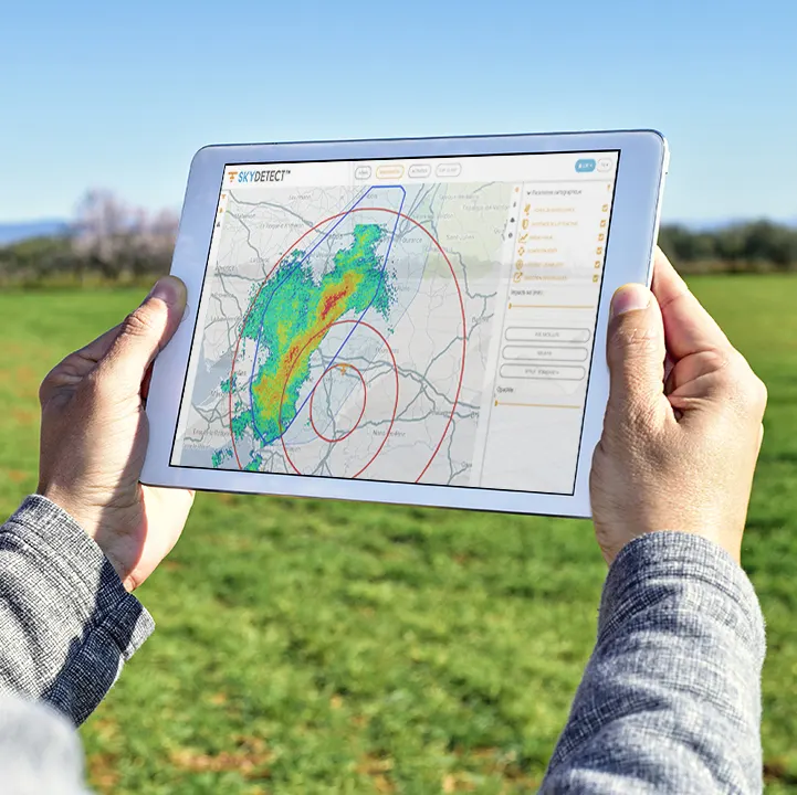 Tablet showing a CIRRUS storm tracking map above a farm field
